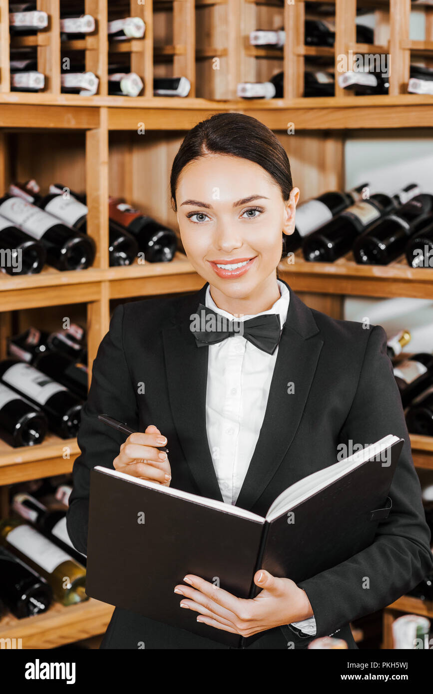 beautiful female wine steward with notebook at wine store Stock Photo