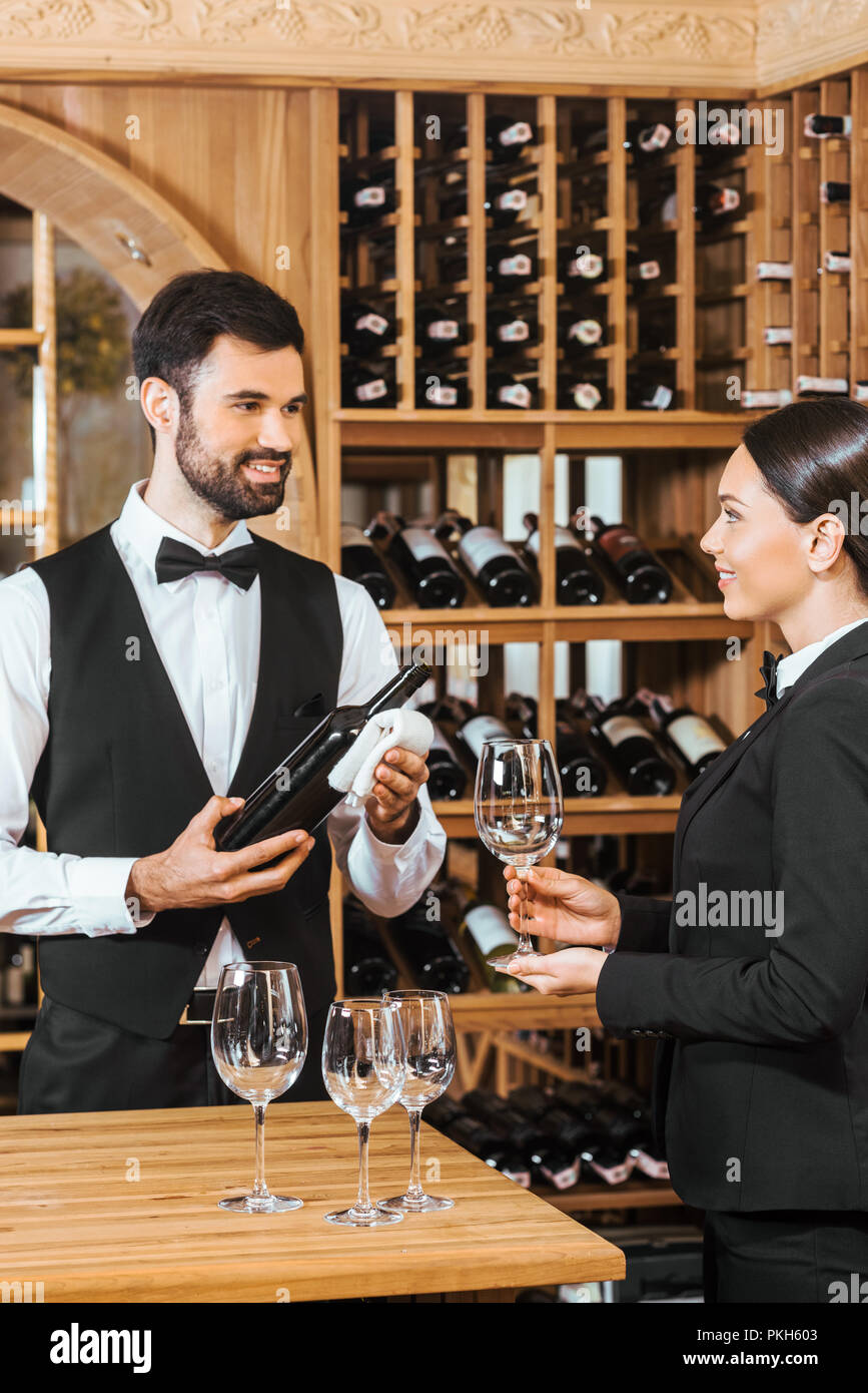 couple of wine stewards pouring wine into glass for degustation at wine