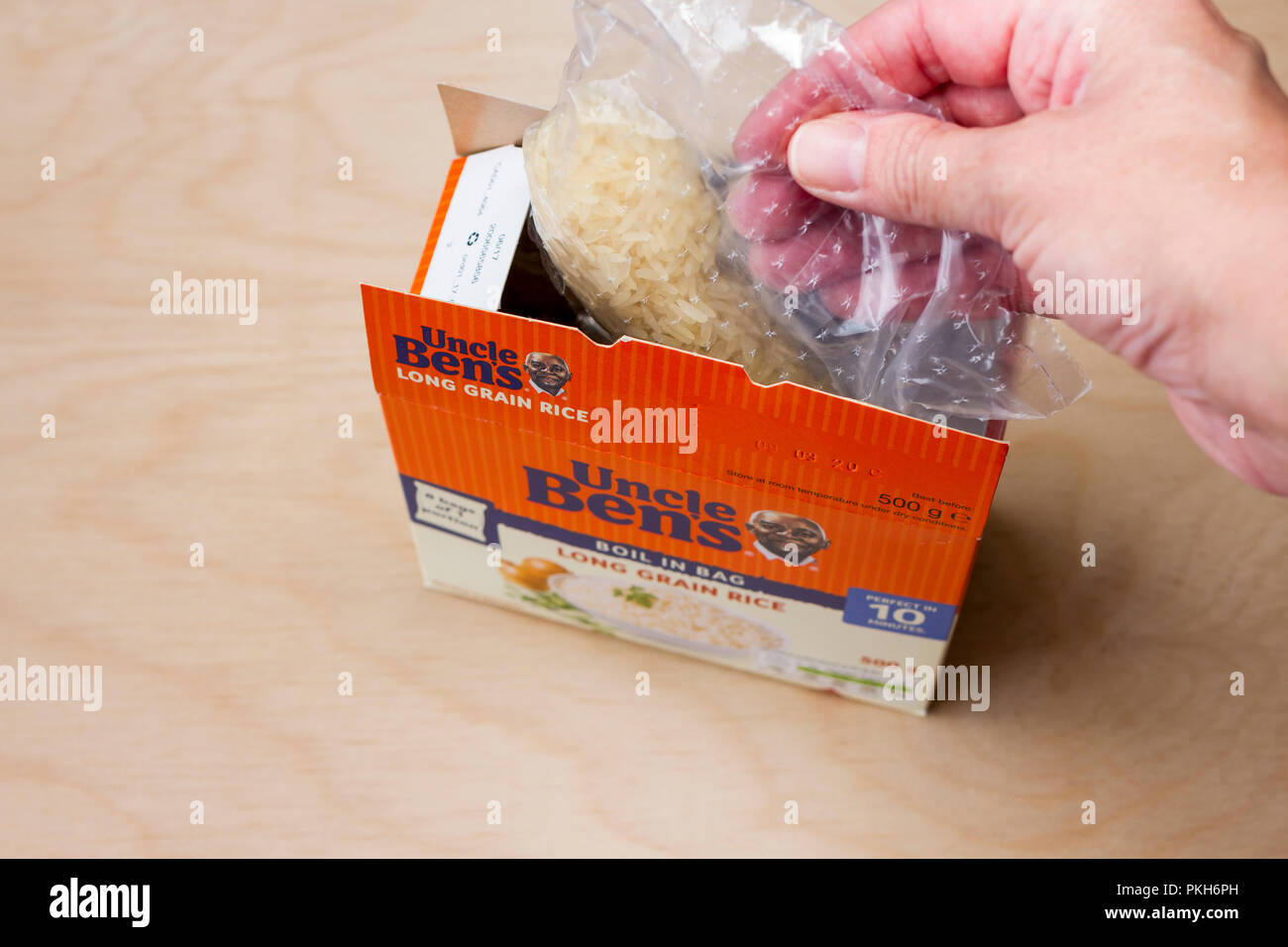Female hand holding a bag of Uncle Ben's boil in the bag rice, United Kingdom Stock Photo