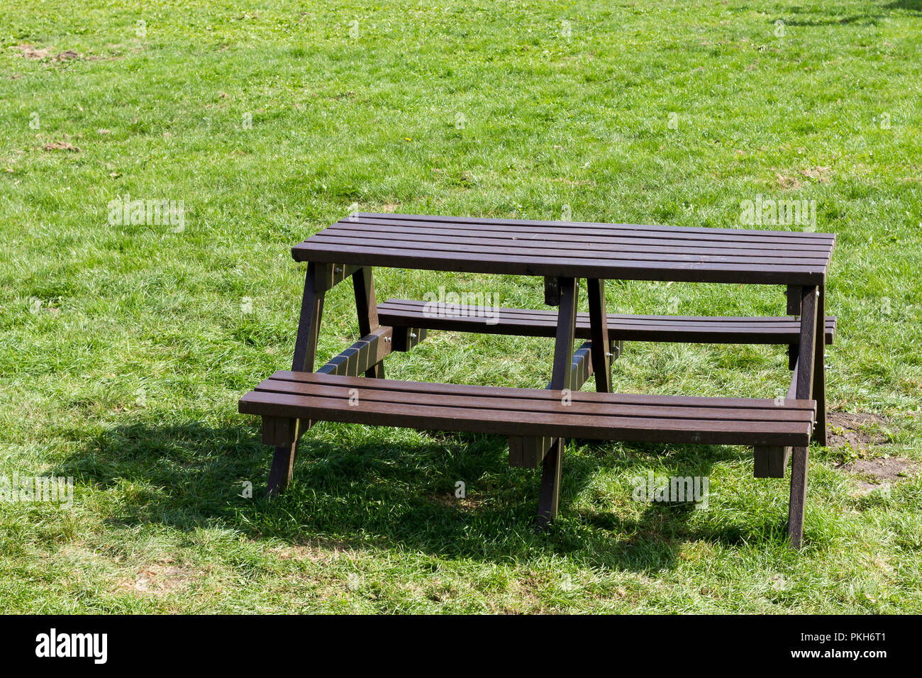 Empty wooden picnic bench, picnic table on grass, Dorset, England, UK Stock Photo