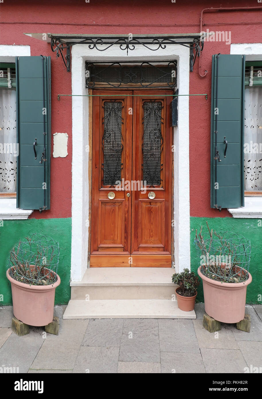 Retro house with closed wooden entrance door and empty flower pots on ...