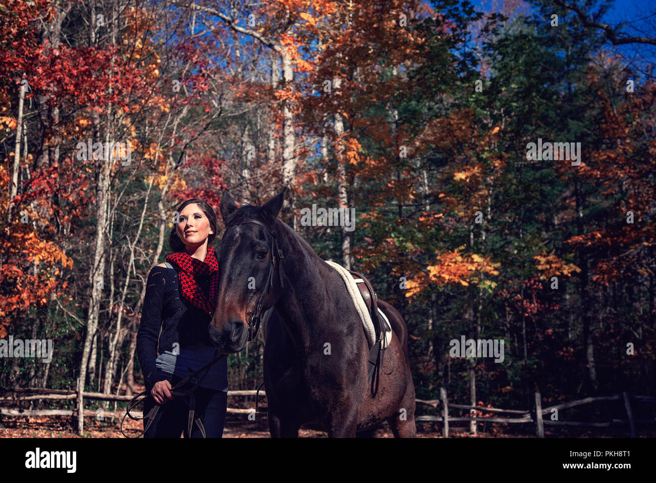 Attractive adult female standing with her horse against the backdrop of Pisgah National Forest Stock Photo