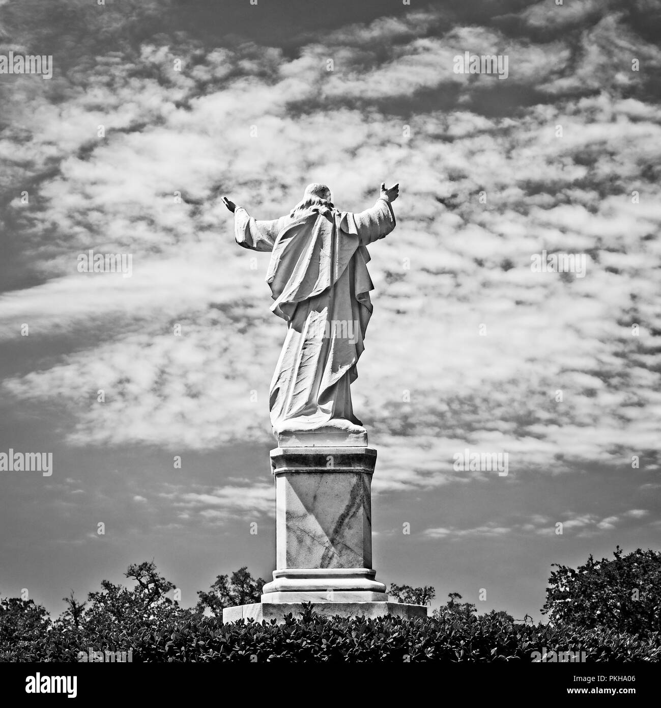 New Orleans, LA USA - May 9, 2018  -  Statue of Jesus with Hands Raised at Loyola University in B&W Stock Photo