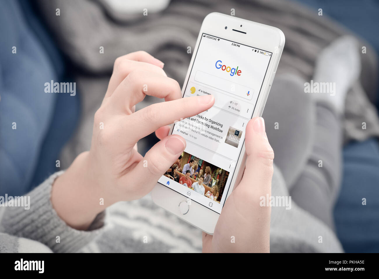 Kyiv, Ukraine - January 24, 2018: Woman using Google app on  Apple iPhone 8 plus at home. Google it is the most-used search engine on the World Wide W Stock Photo