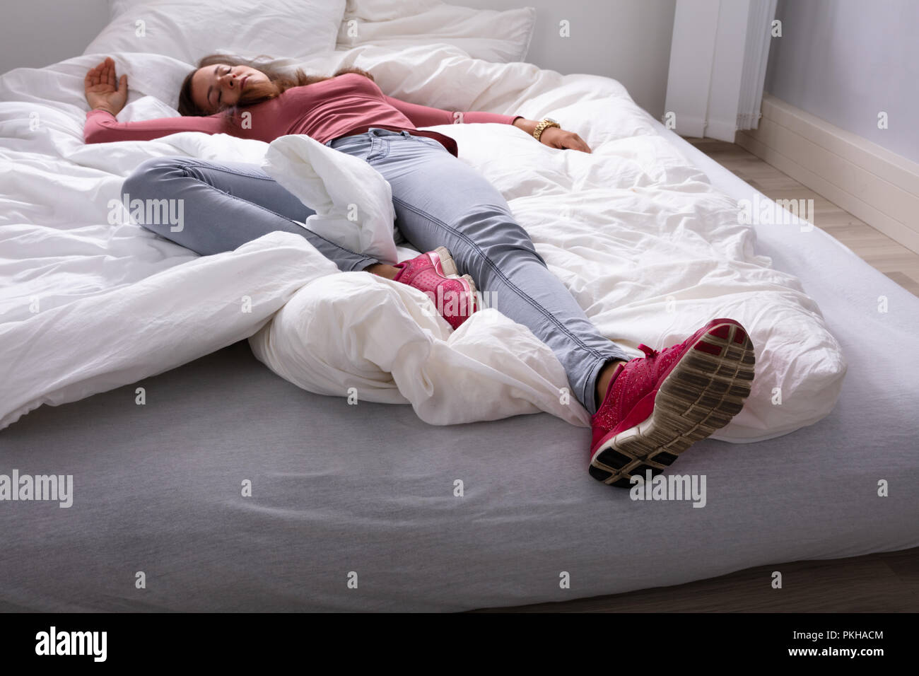 Young Woman Sleeping On Bed In Bedroom Stock Photo