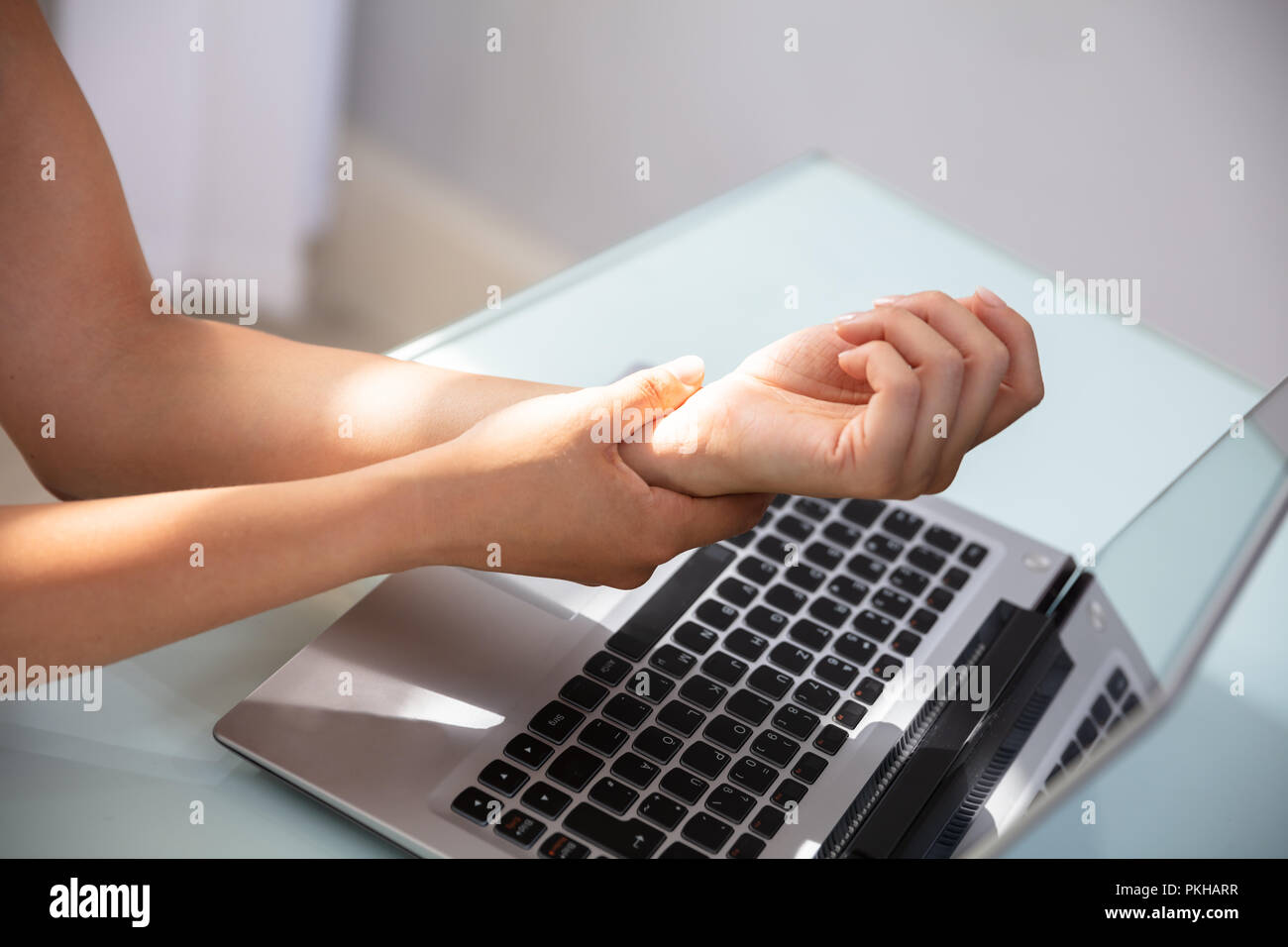 Businesswoman Holding Painful Wrist With Laptop On Desk Stock Photo Alamy