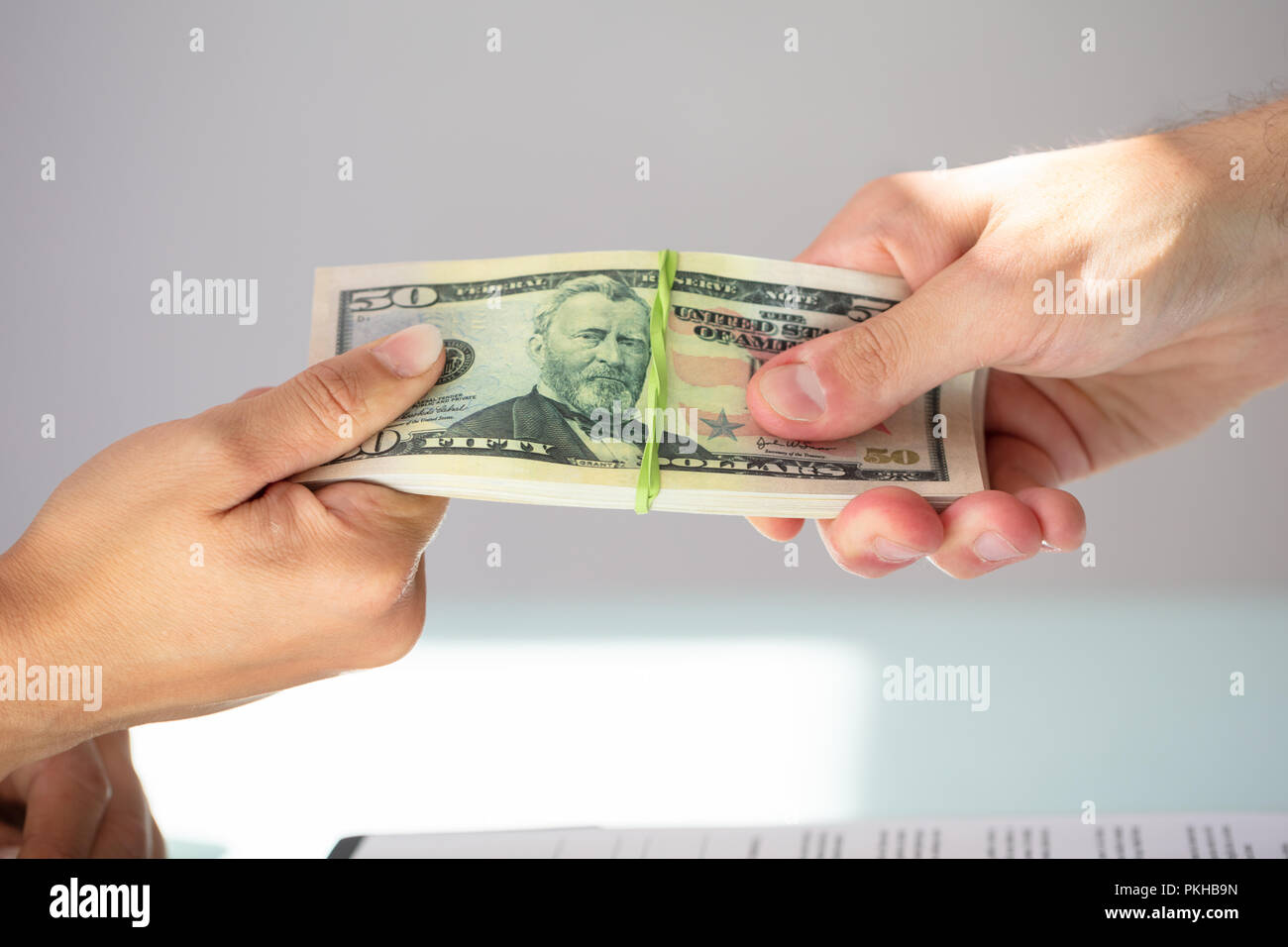 Close-up Of A Businessperson's Hand Taking Bribe From Partner Stock Photo
