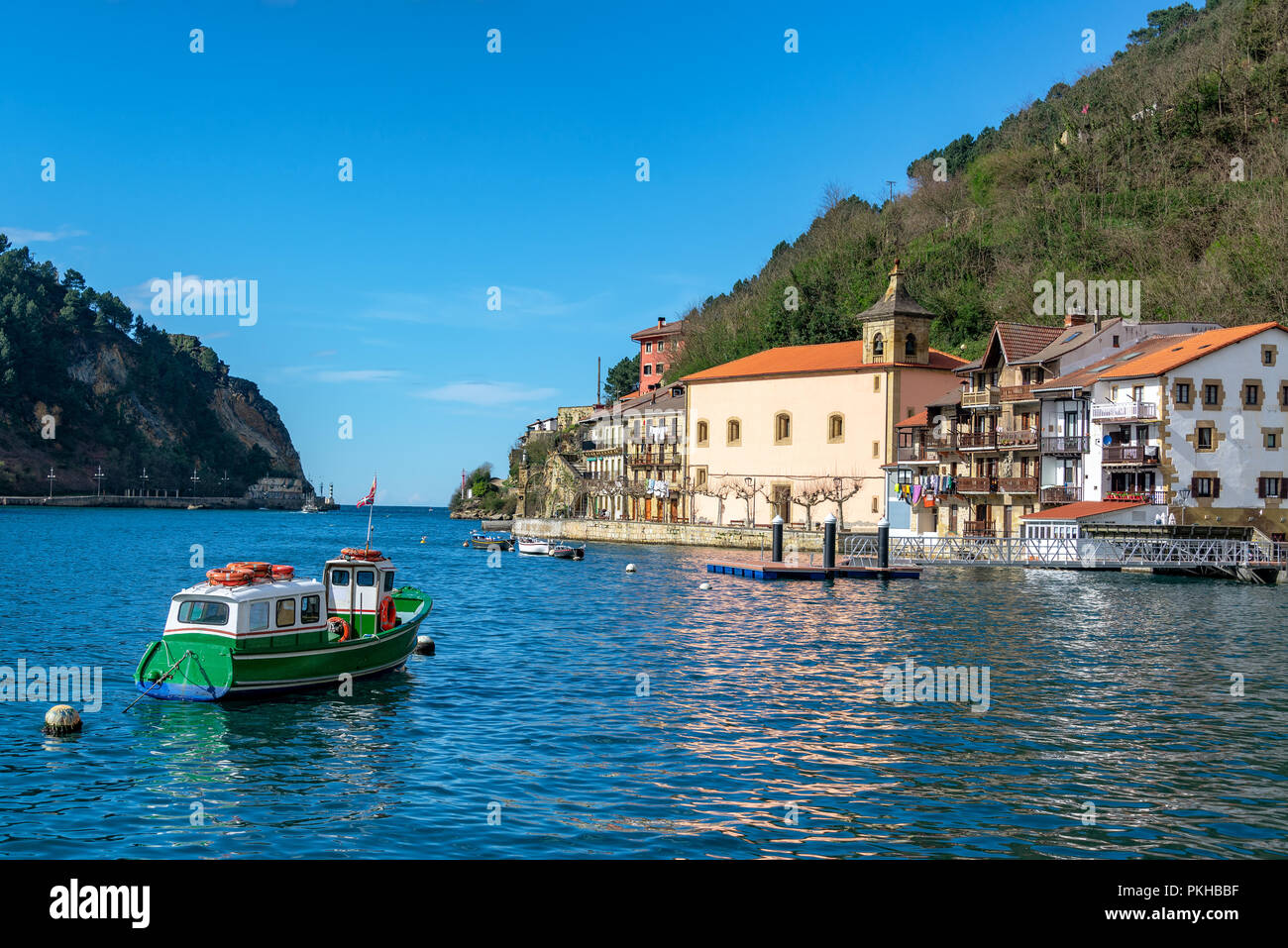 Small boat and the quaint historic town of Pasai Donibane, Spain Stock Photo