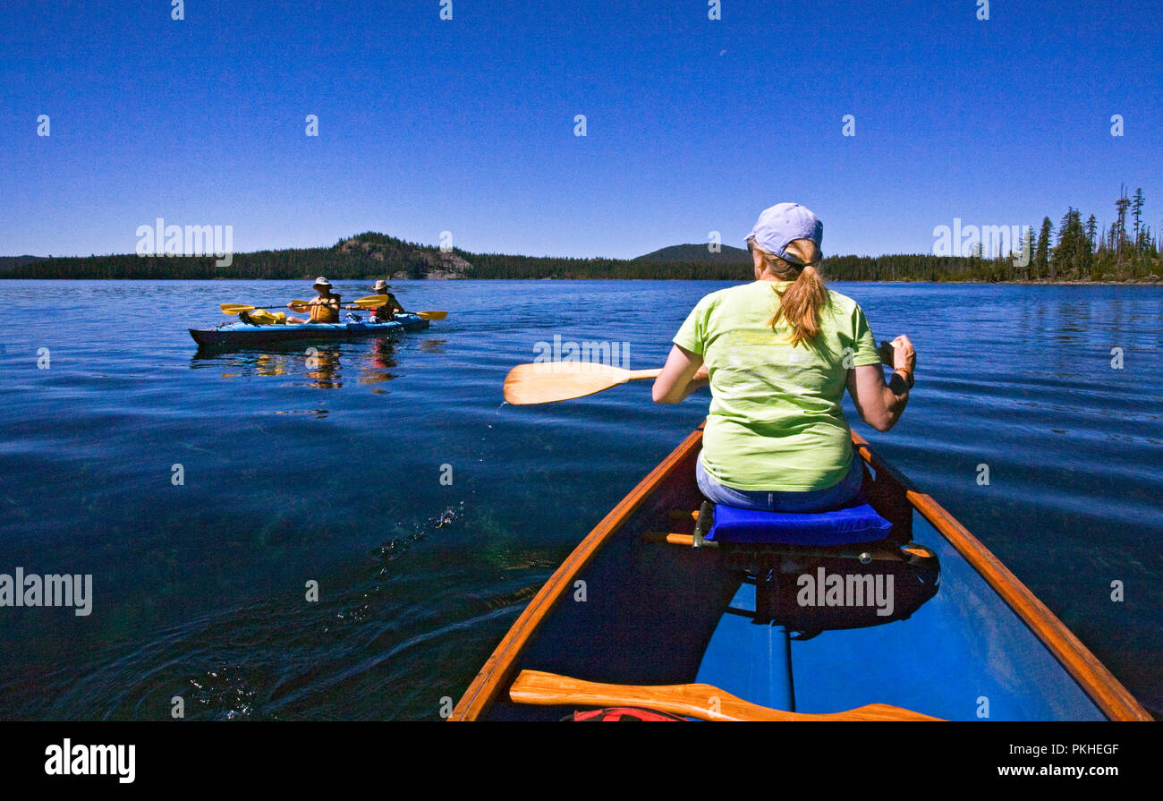 A middle aged married couple paddling a two-person kayak on Waldo Lake, a volcanic caldera lake in the central Oregon Cascades near the town of Oakrid Stock Photo