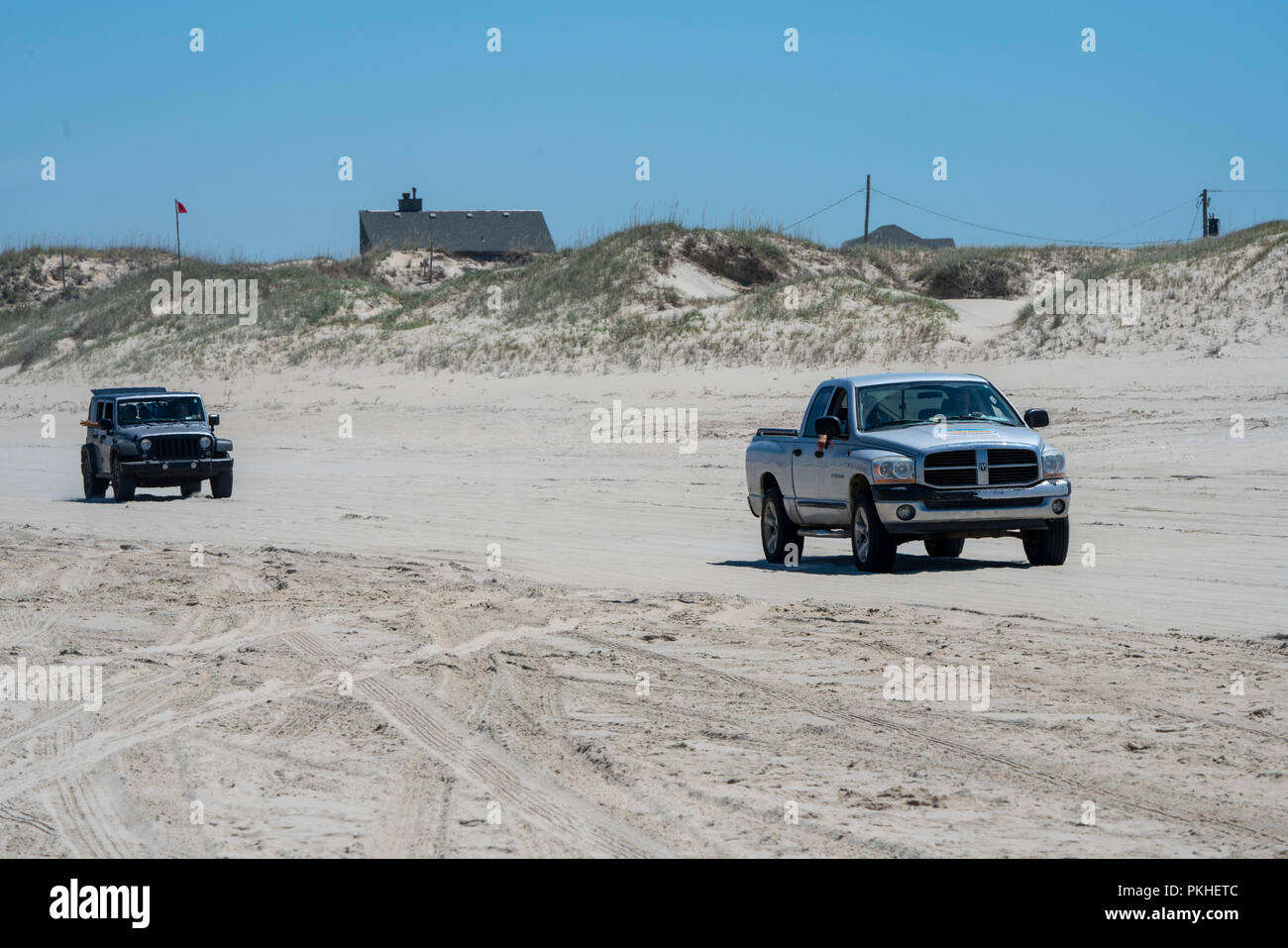 Jeep Wrangler and Ram Pickup truck driving on the beach in the Carova