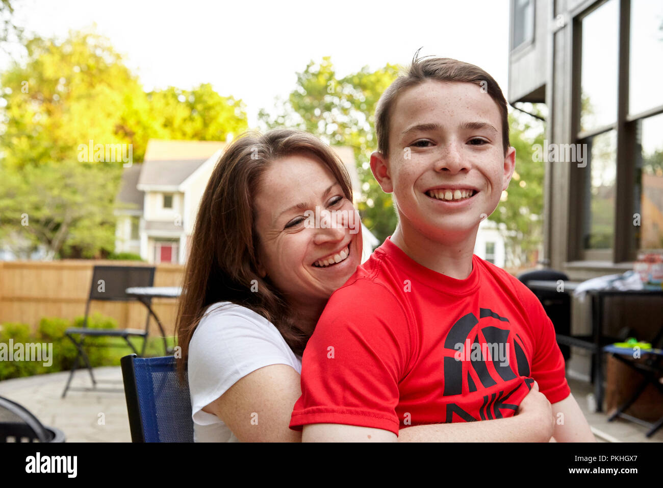 son sitting on mothers lap smiling Stock Photo