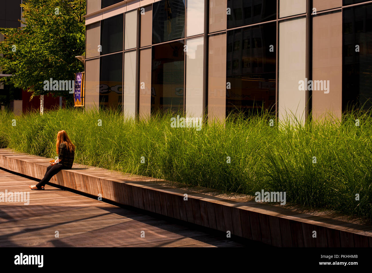 Woman taking a lunch break sitting on bench downtown Seattle. Stock Photo