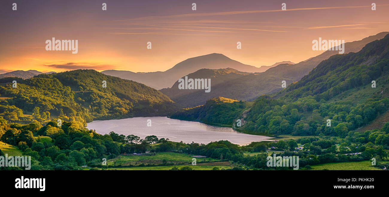 The Sun shining through a mountain pass over Llyn Gwynant, Snowdonia (Eryri), Wales (Cymru), UK Stock Photo