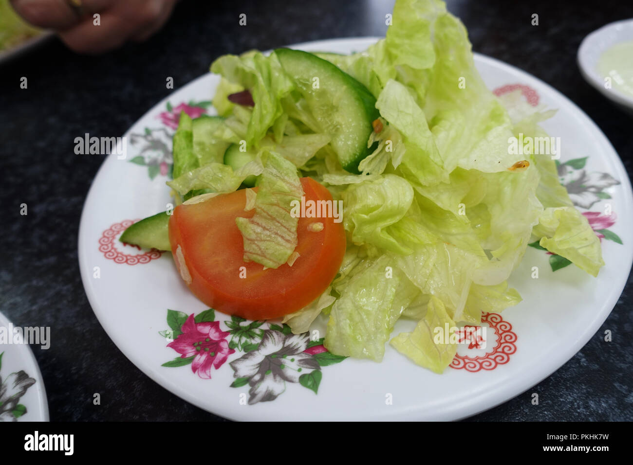Freshly cut iceberg lettuce, tomato and cucumber on a plate Stock Photo