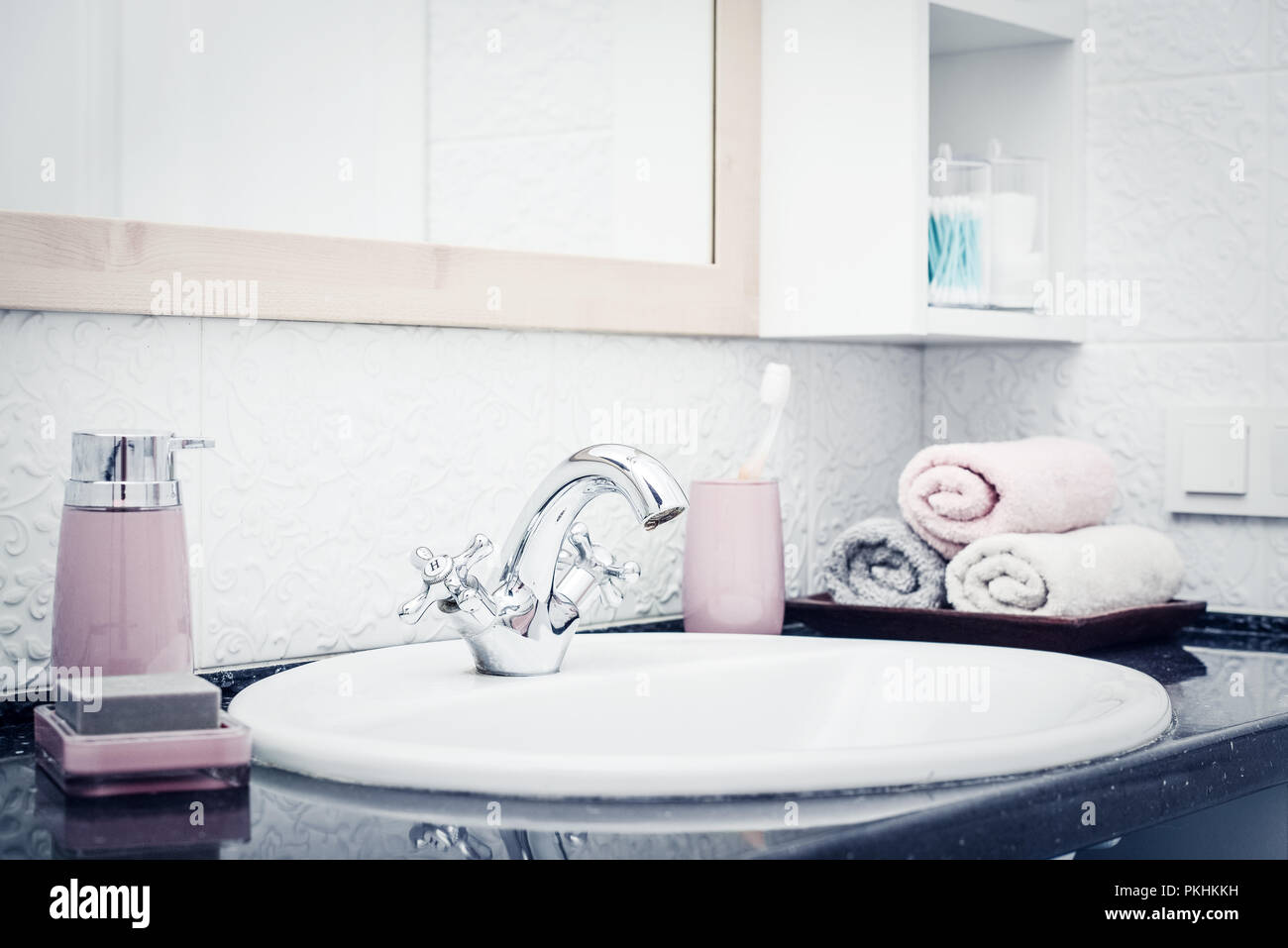Stack of towels  in the bathroom with liquid soap dispenser  and tooth brushes  closeup Stock Photo