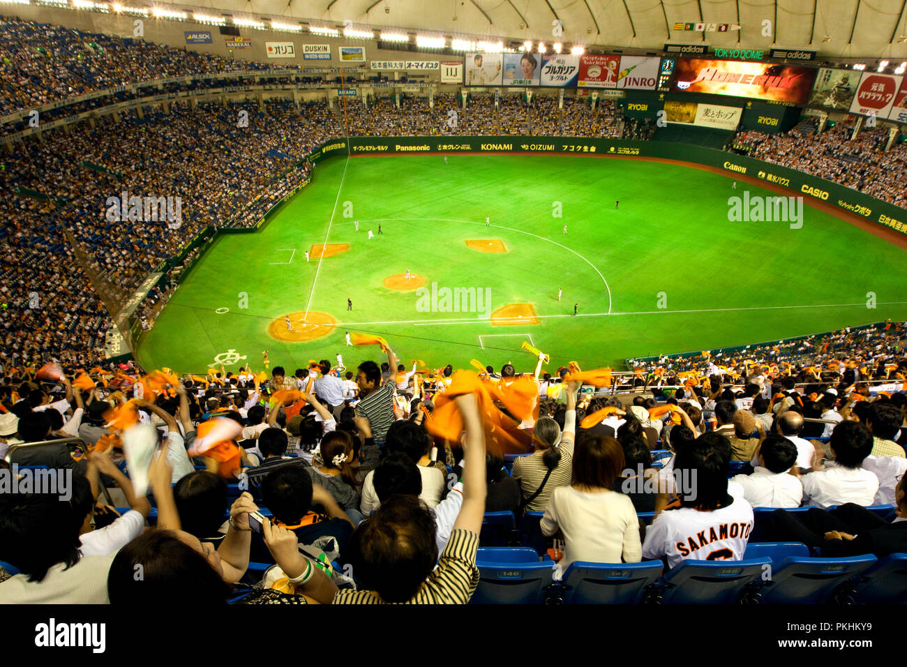 Tokyo Dome baseball stadium in Tokyo on Sept. 17, 2009. Fans wave orange banners for their team the Yomiuri Giants. Wide angle view from top Stock Photo