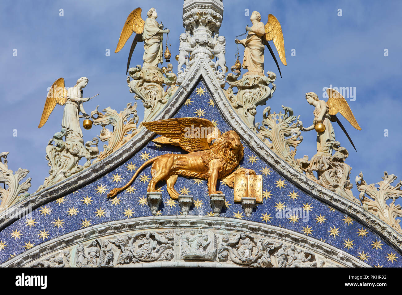 San Marco golden winged Lion statue with angels on basilica facade, symbol of Venice in a sunny day in Italy Stock Photo