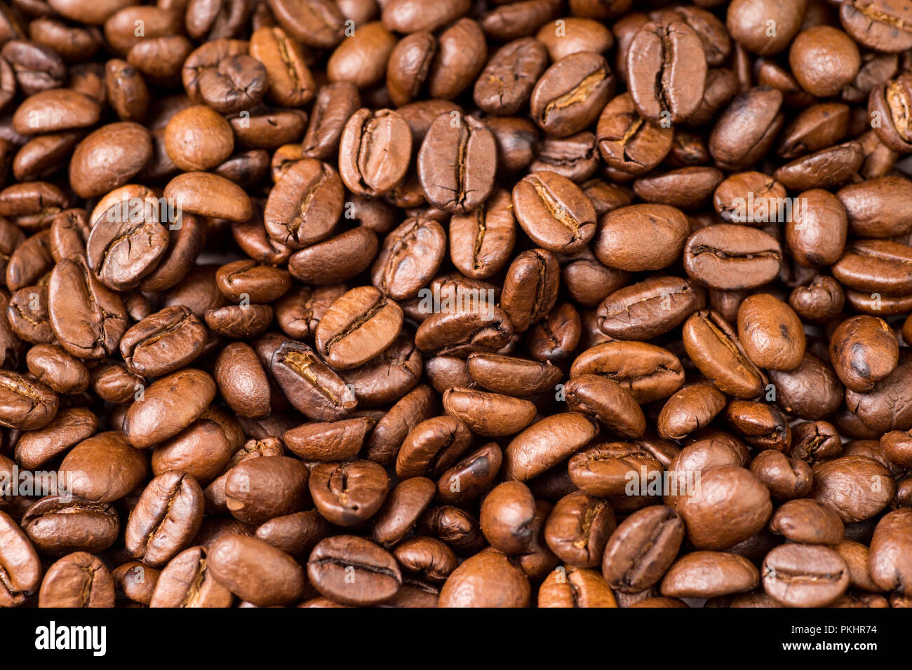 Roasted organic whole dark coffee beans, close up Stock Photo