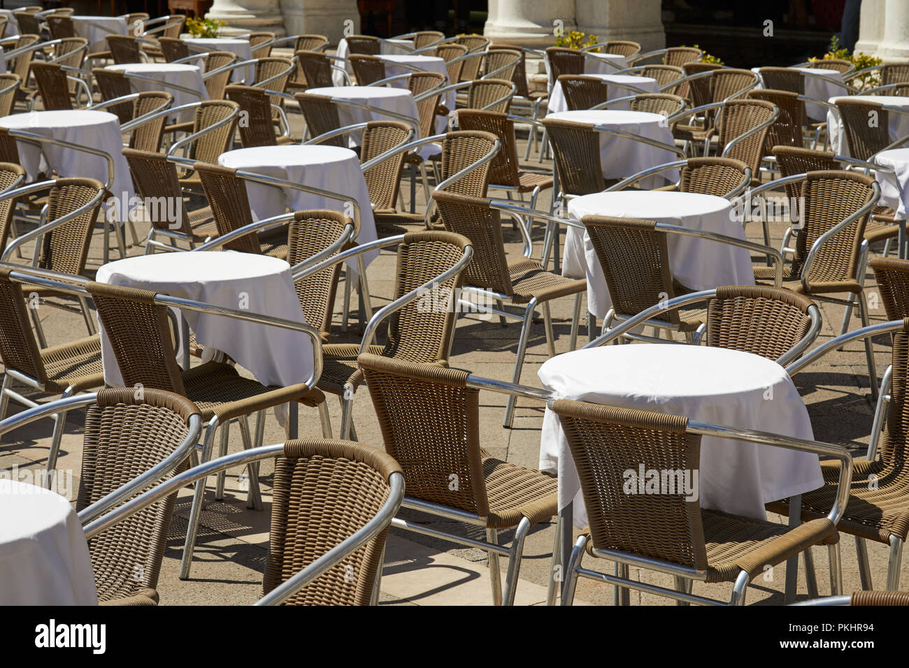 Sidewalk tables and chairs in a sunny summer day in Italy, nobody Stock Photo