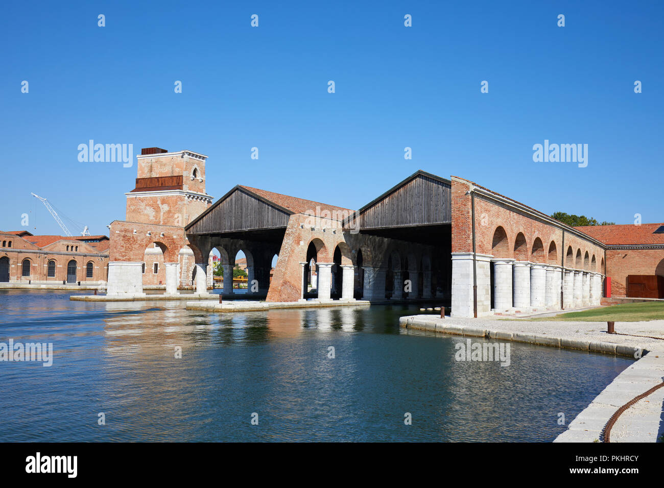 Venetian Arsenal with docks, canal and arcade, blue sky in summer in Venice, Italy Stock Photo