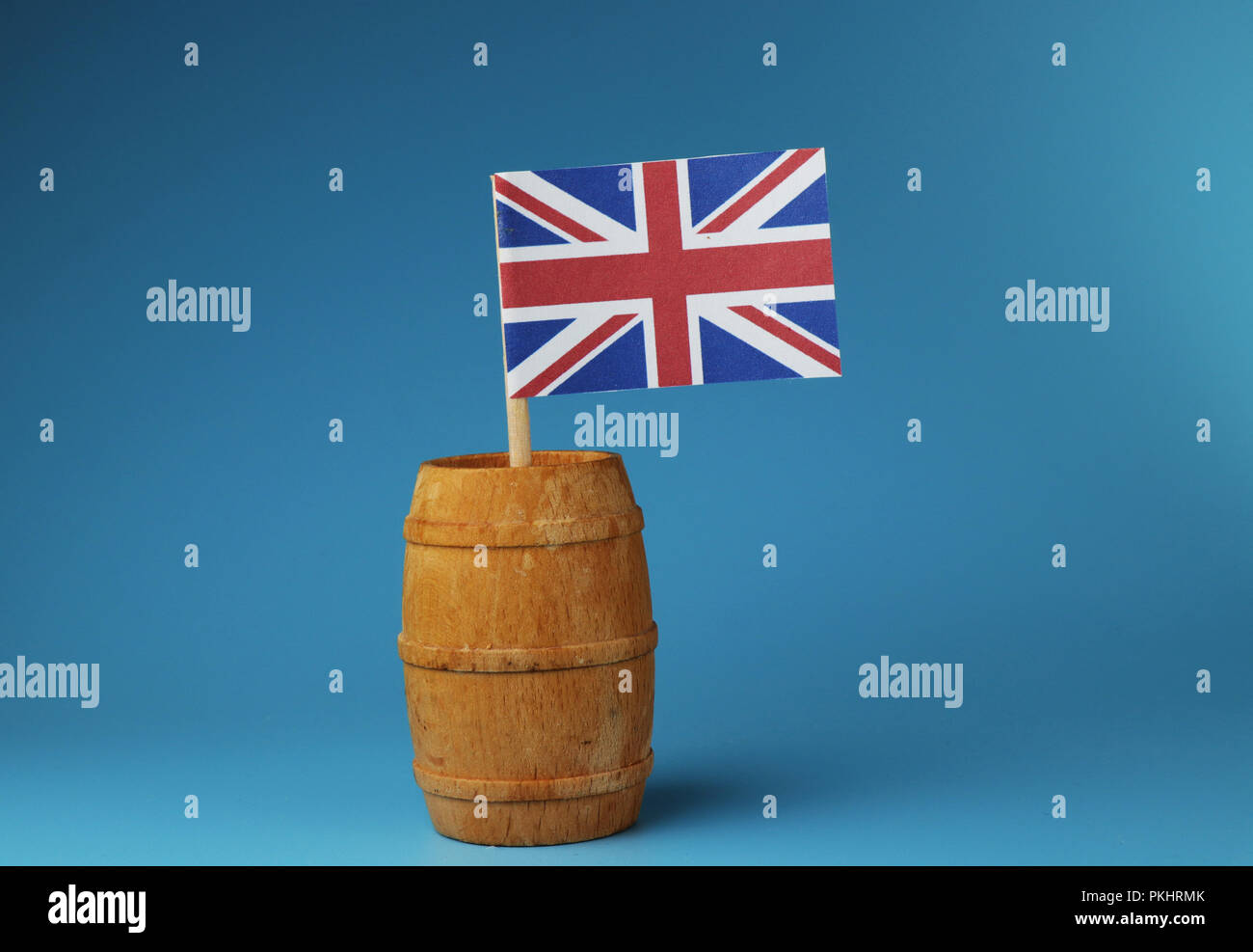 A flag of United kingdom, Great Britain, on wooden stick in wooden barrel. Blue background Stock Photo