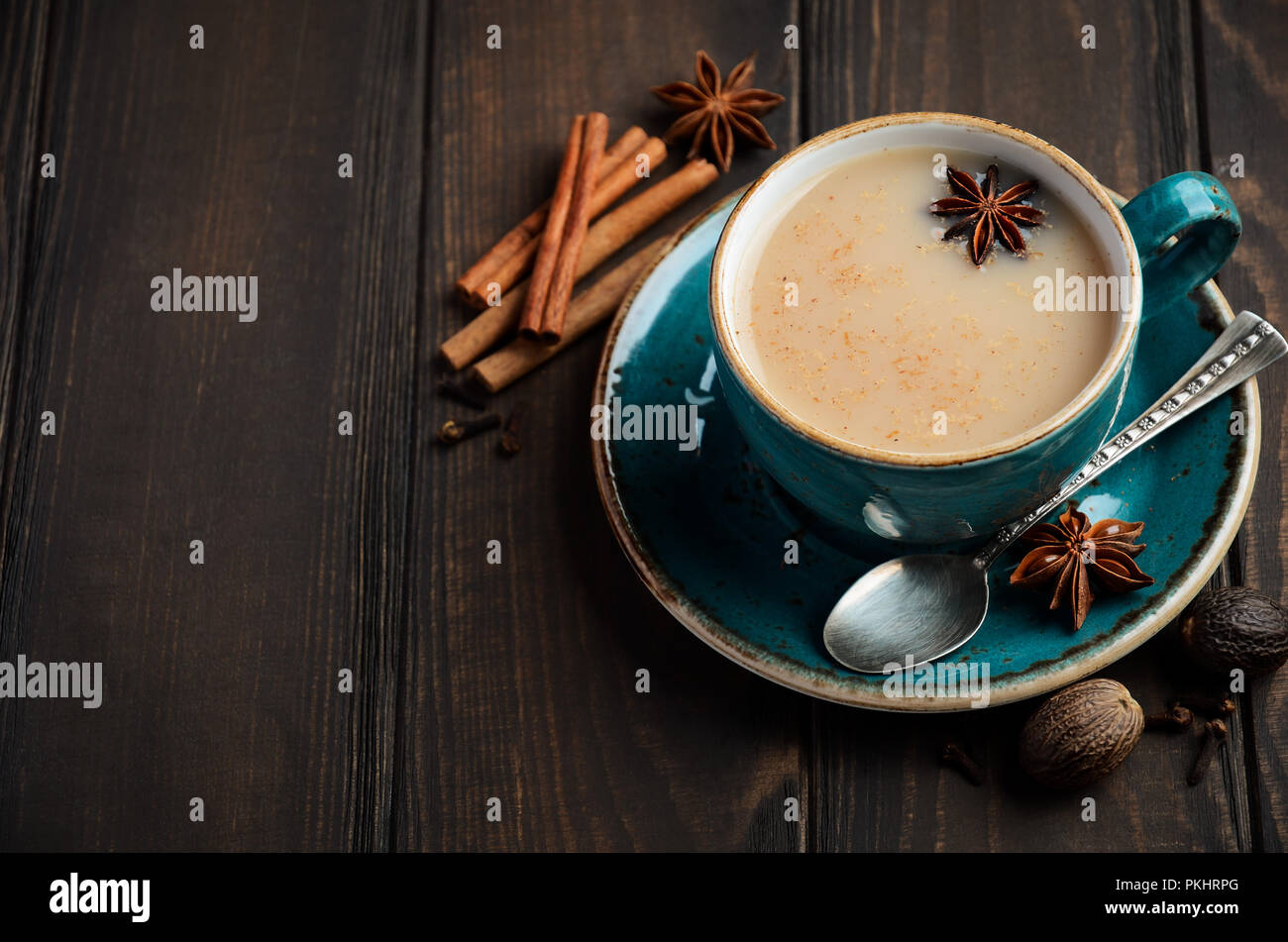 Indian masala chai tea. Spiced tea with milk on dark  wooden table. Stock Photo