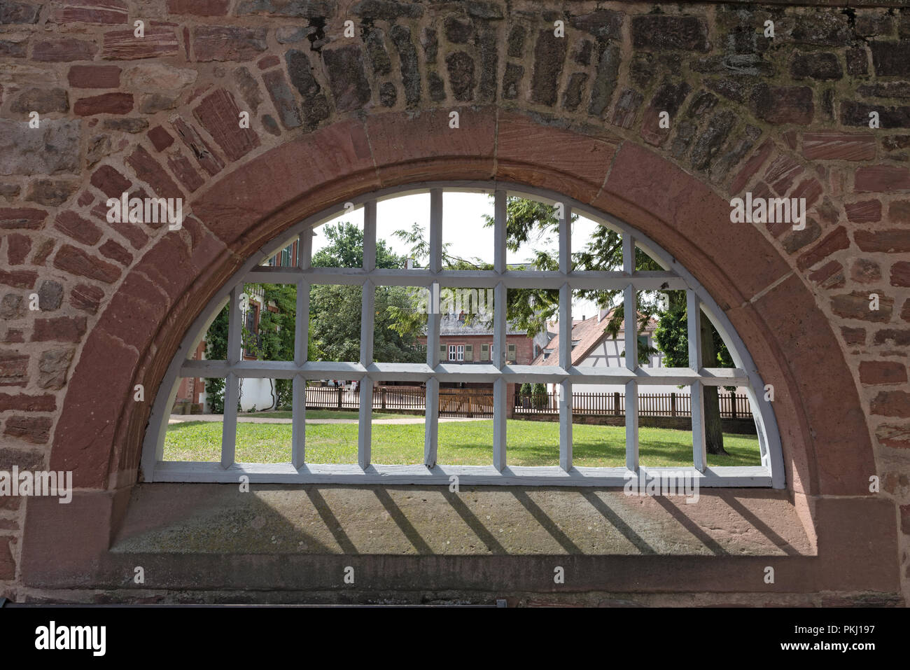 Monastery wall with iron lattice window, Seligenstadt, Hesse, Germany. Stock Photo