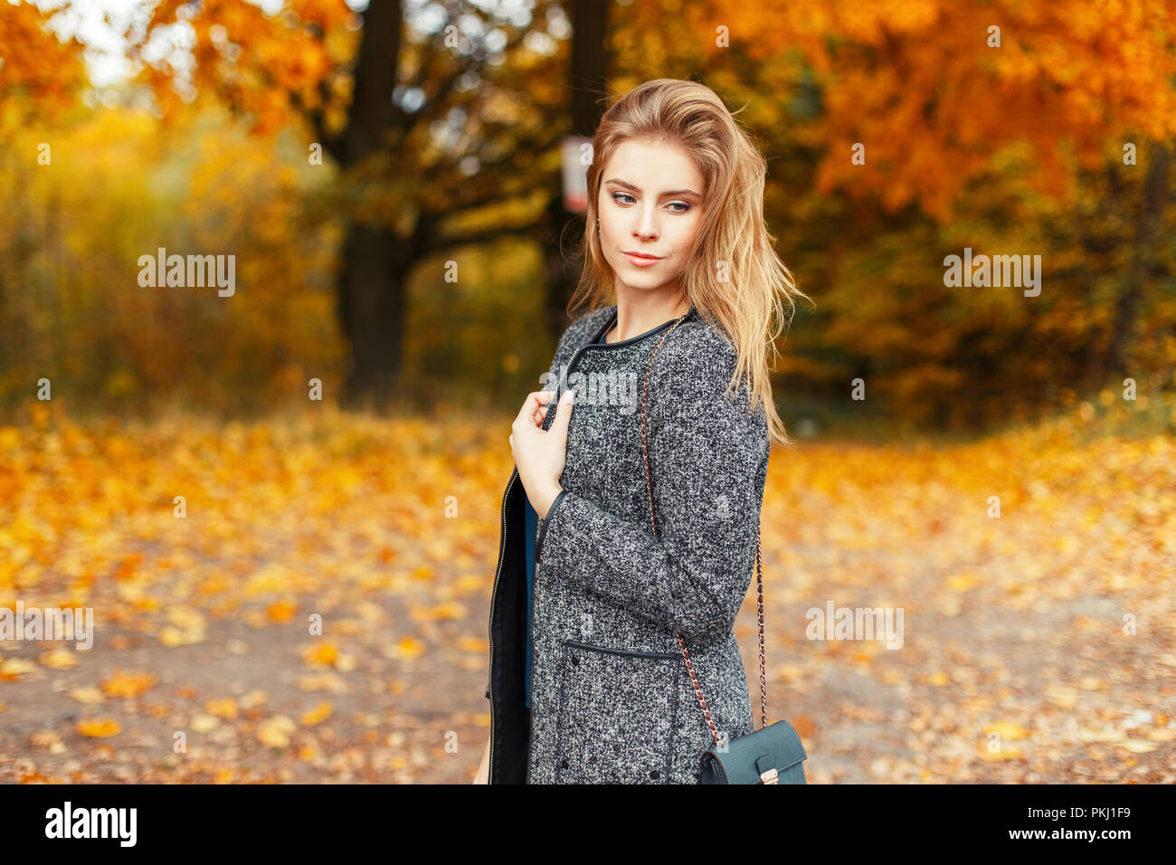 Happy beautiful young woman with a smile in a trendy coat posing in a ...