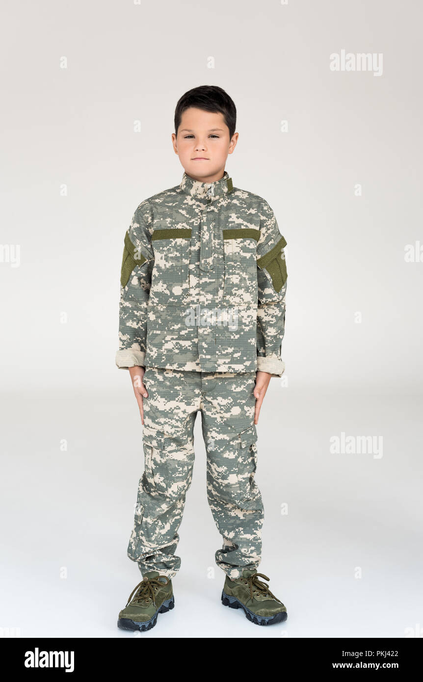 little kid in military uniform posing on grey background Stock Photo