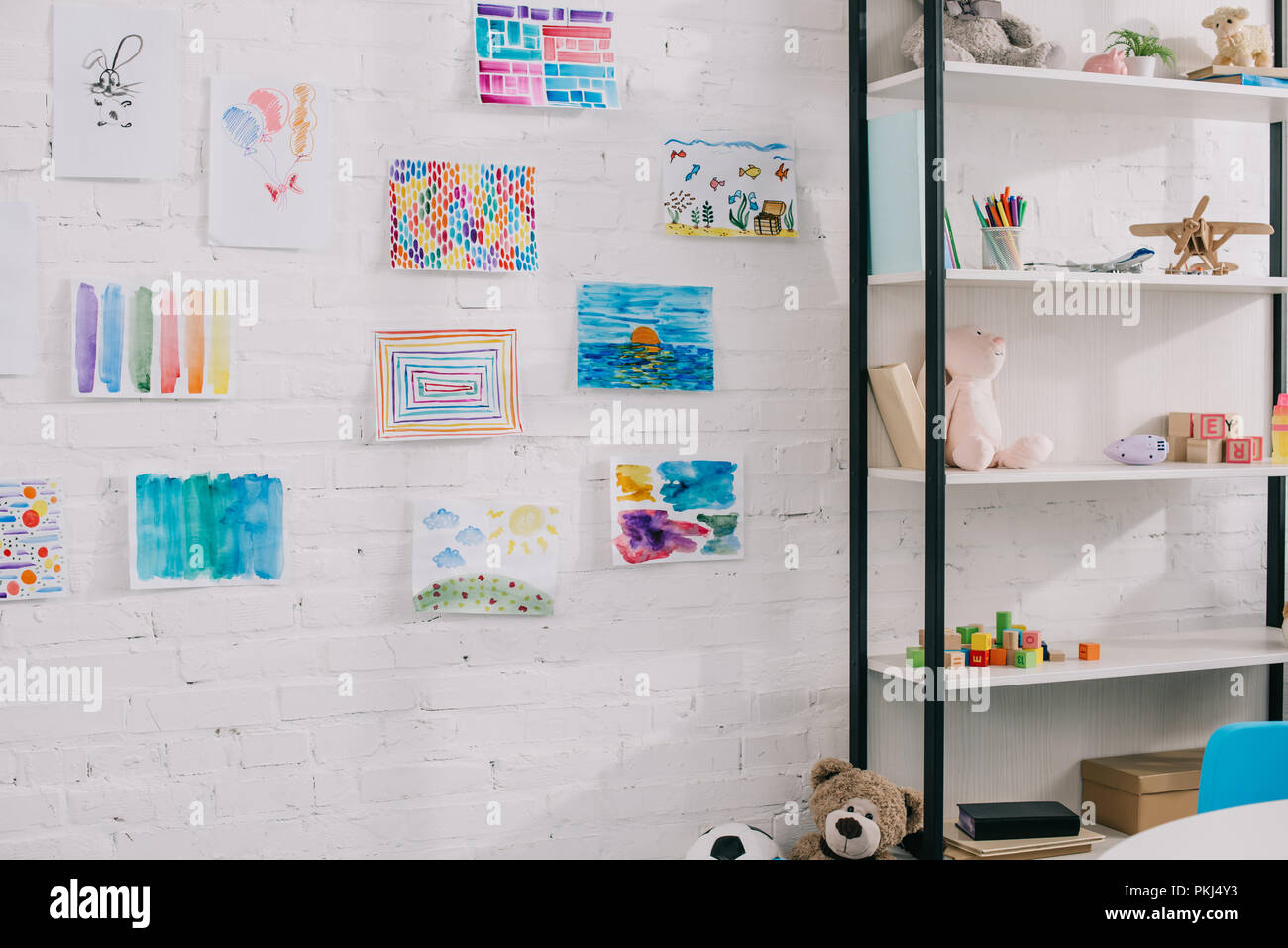 Close Up View Of Colorful Pictures Hanging On White Brick