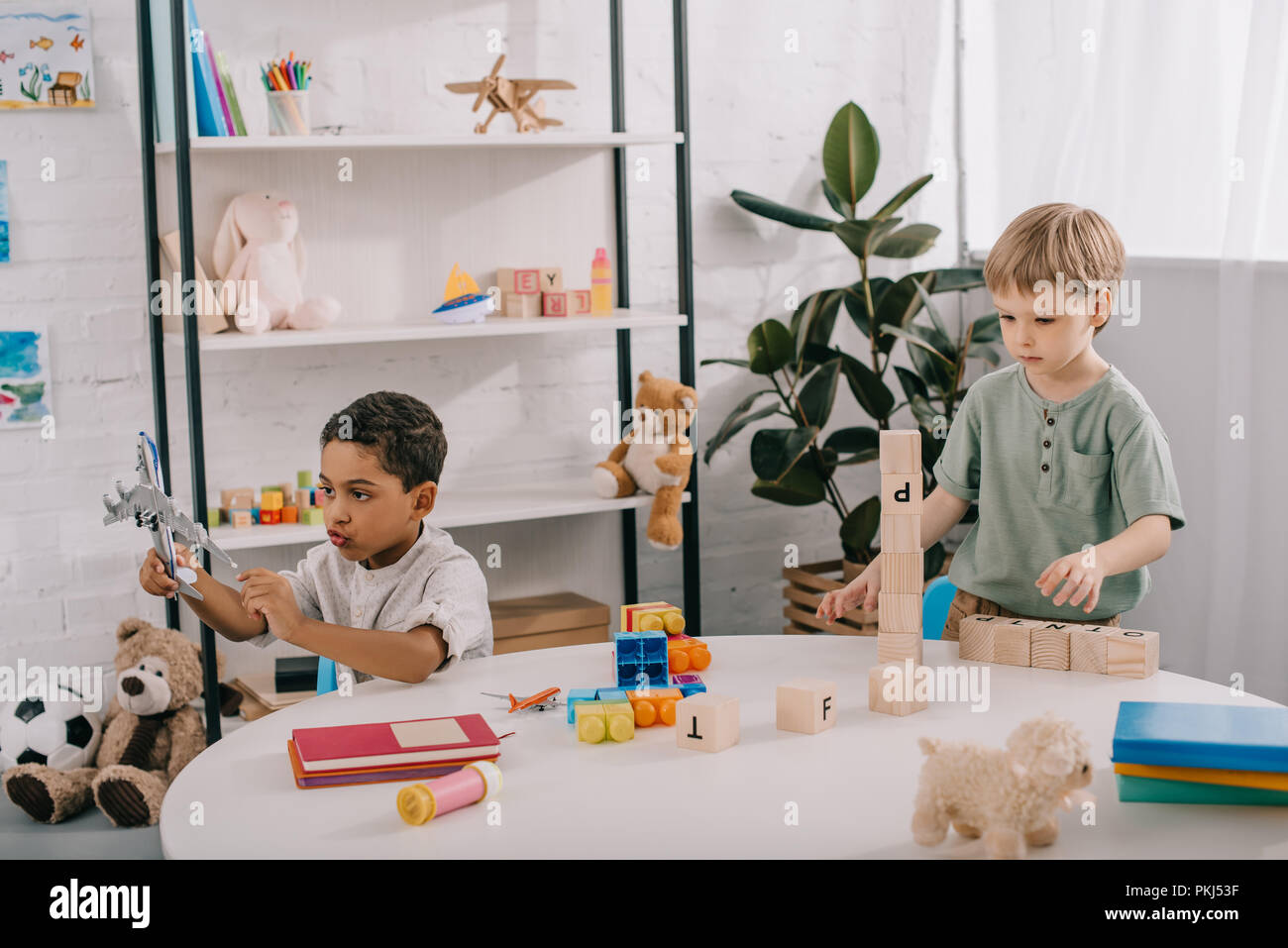 multicultural boys playing with toys in classroom Stock Photo Alamy