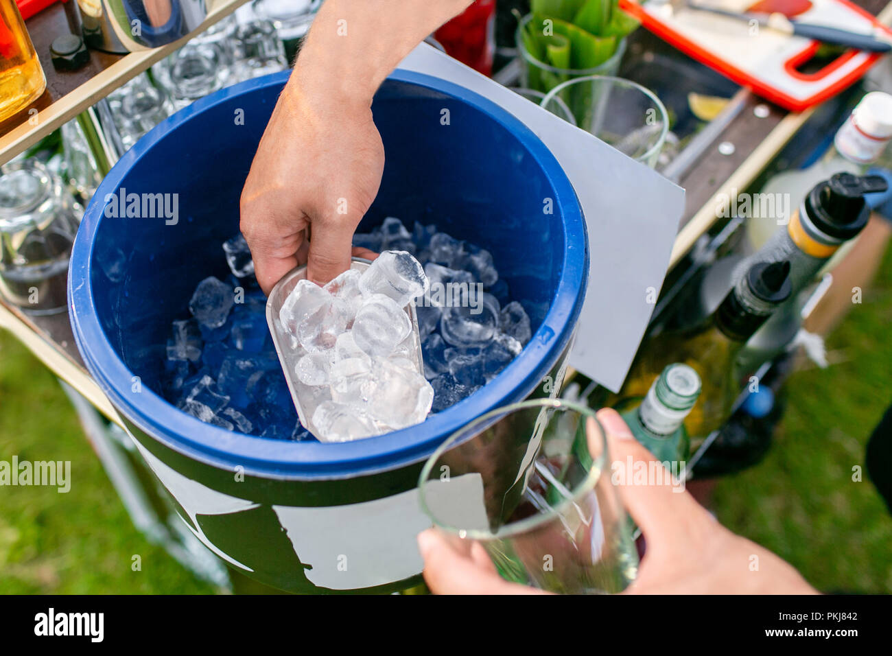 Bartender makes cocktail . Ice bucket with full of ice cubes