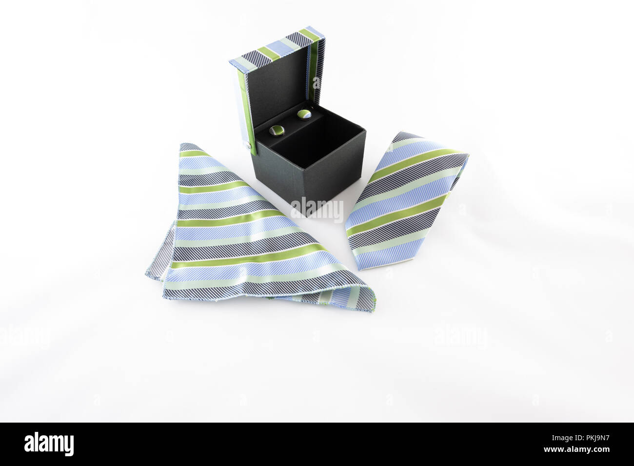 Neck tie, cufflinks and square scarf, black,  blue and green seam geometric pattern, textured multicolor stripes fabric, set in the gift box, on white Stock Photo