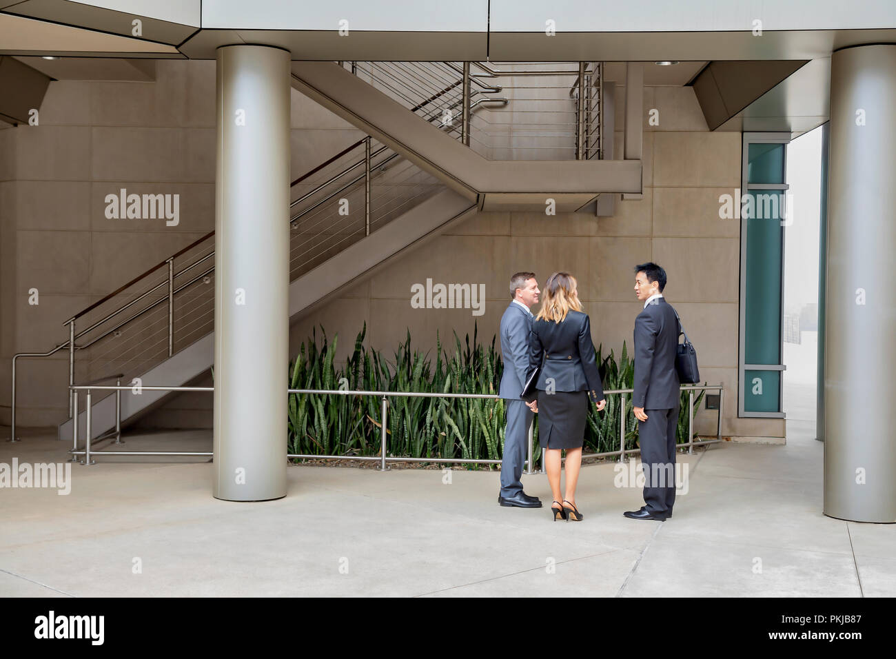 Three executives talking in their office building Stock Photo