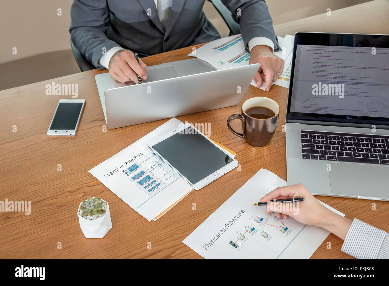 A male and a female colleague working together at the same desk Stock Photo