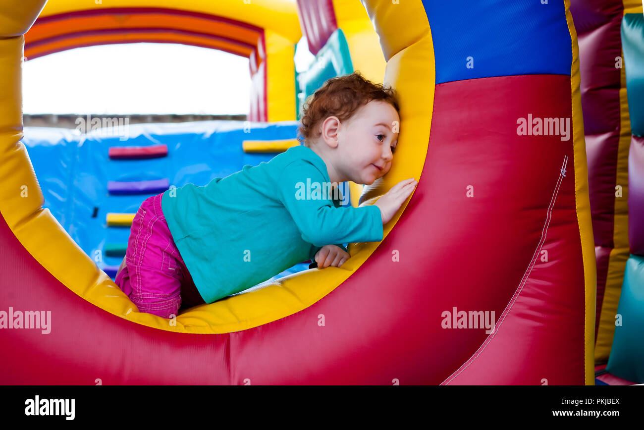 Adorable toddler hiding in a trampoline castle Stock Photo Alamy