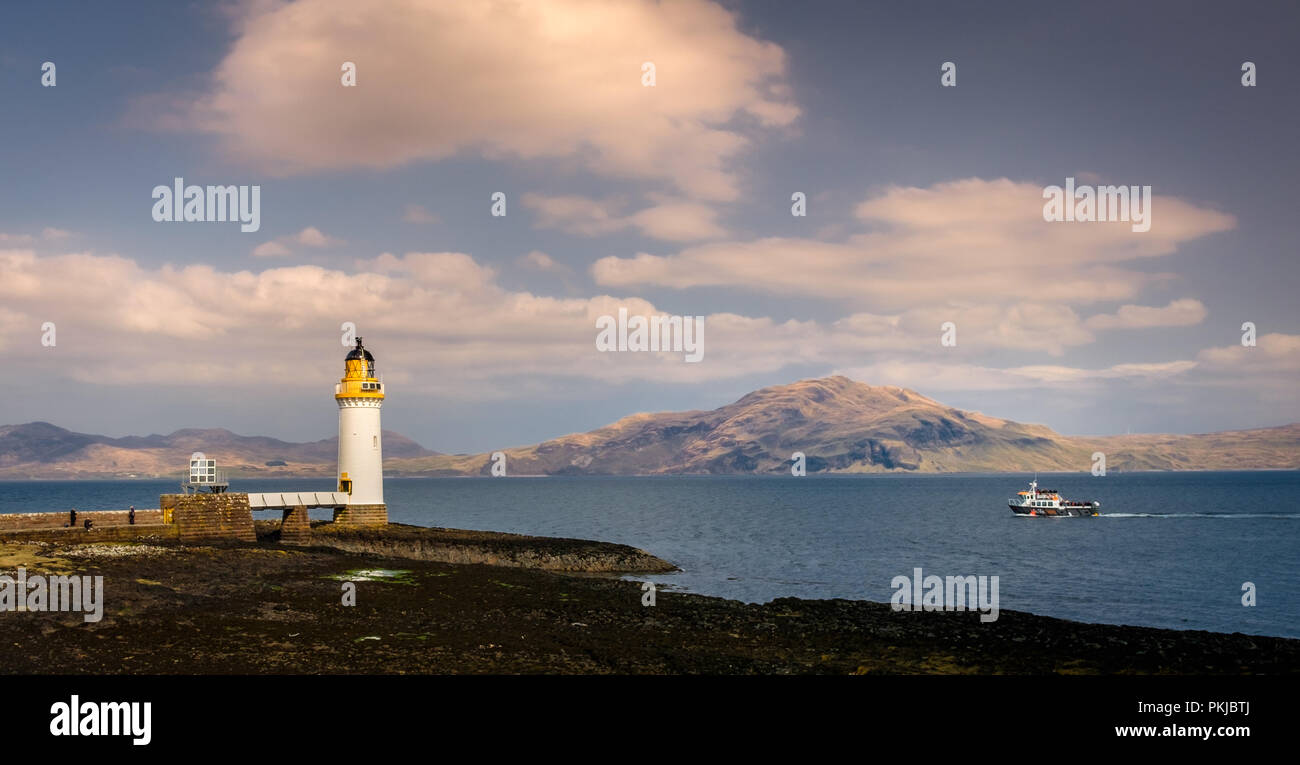 Tourist boat sailing past the lighthouse of Tobermory on the Isle of Mull, Wednesday 11 April 2018, Tobermory, Scotland Stock Photo