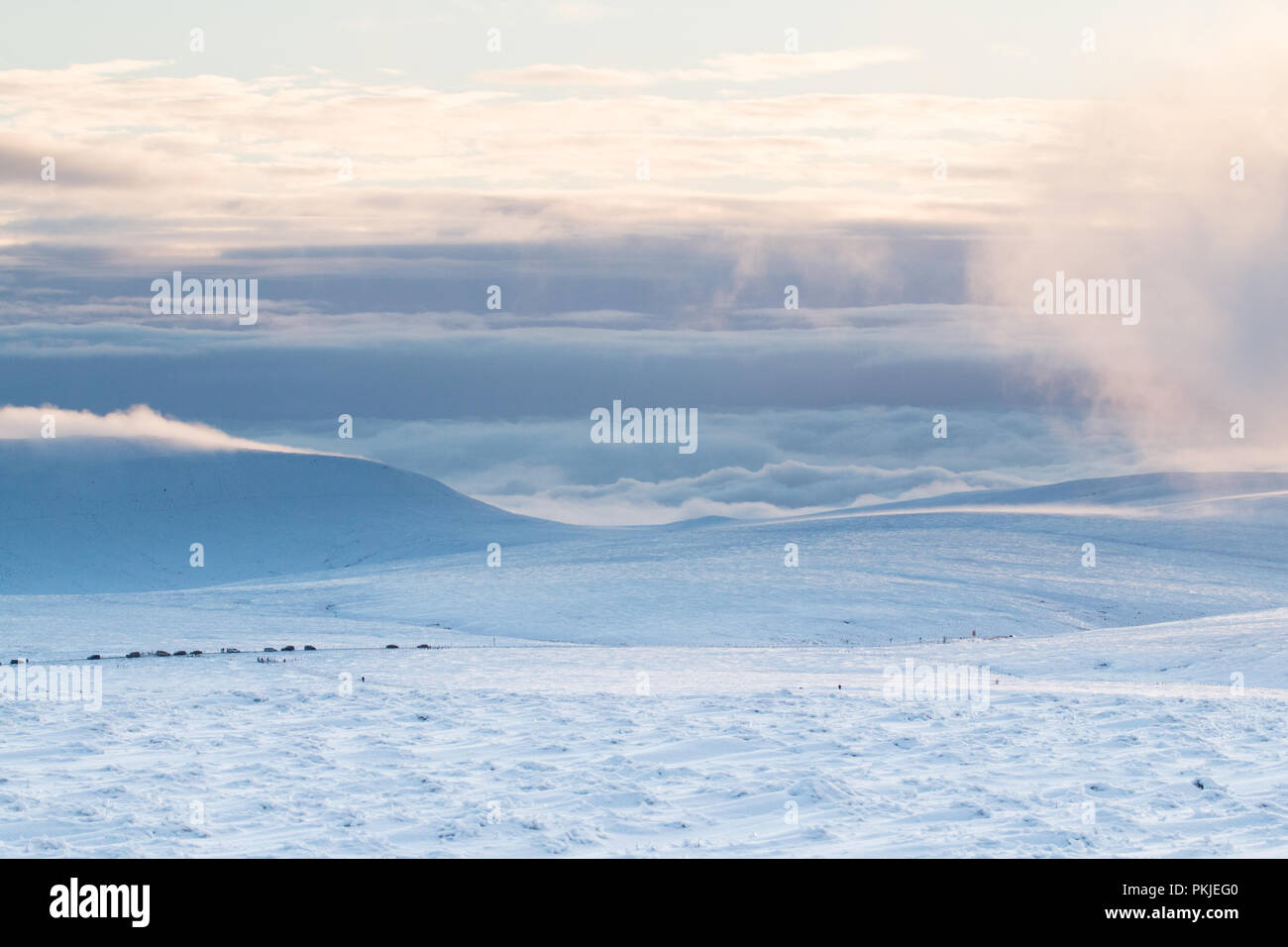 The view from Bleaklow towards Manchester and Glossop over snow covered hills and cloud inversion. Stock Photo