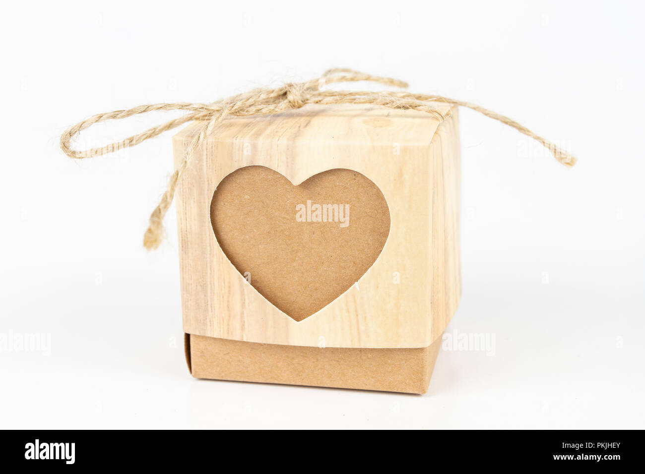 Boxes with the word love on a white table. A gift in a box with a heart cut out. White background. Stock Photo