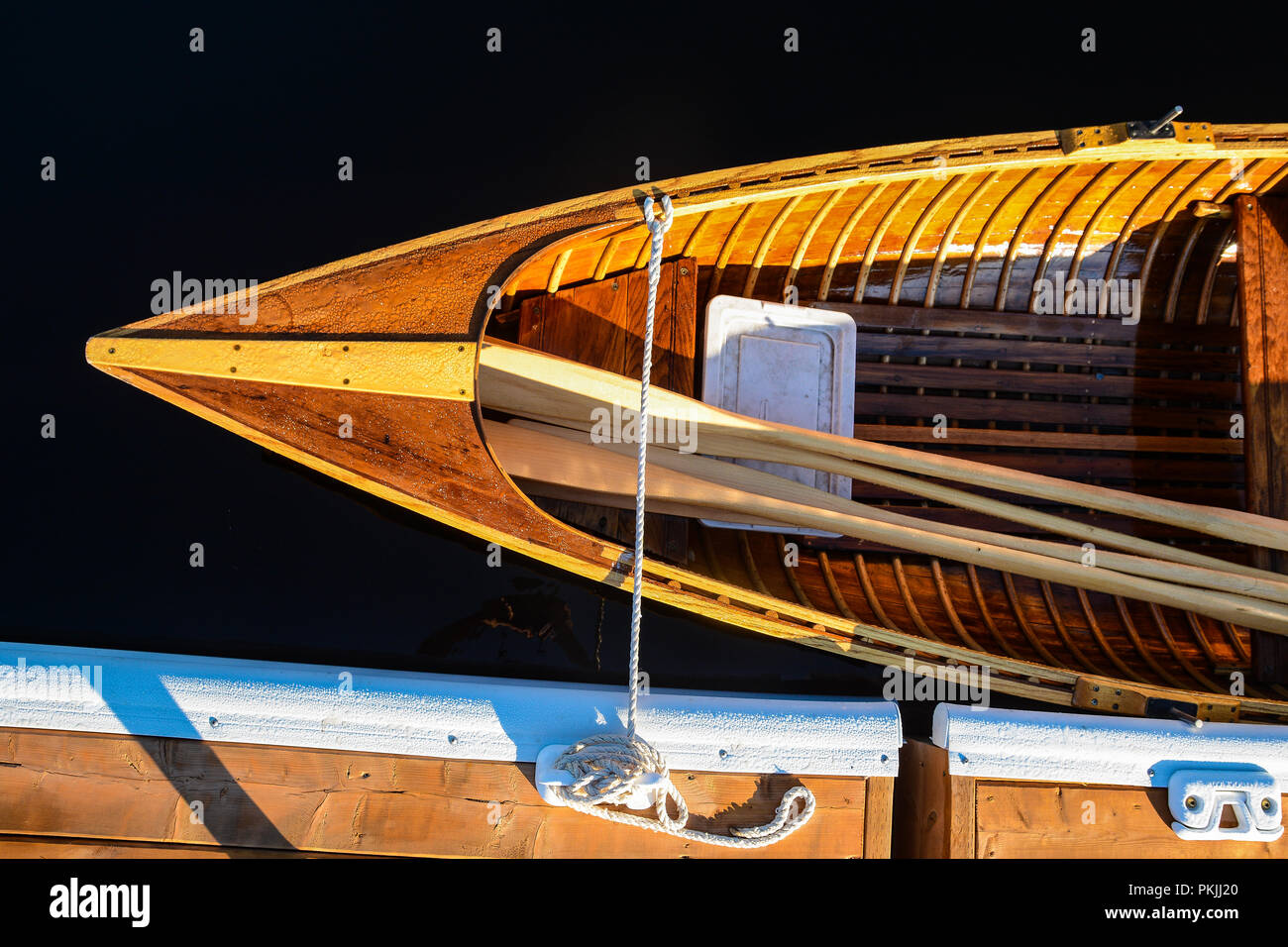 Wooden row boat docked with oars Stock Photo