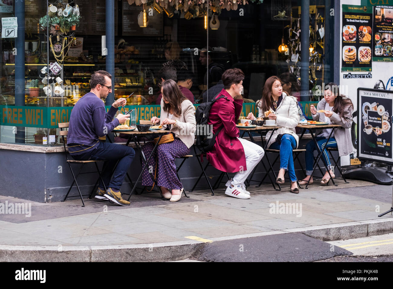 People at tables outside of Toi & Moi Café, Soho, London, England, U.K. Stock Photo