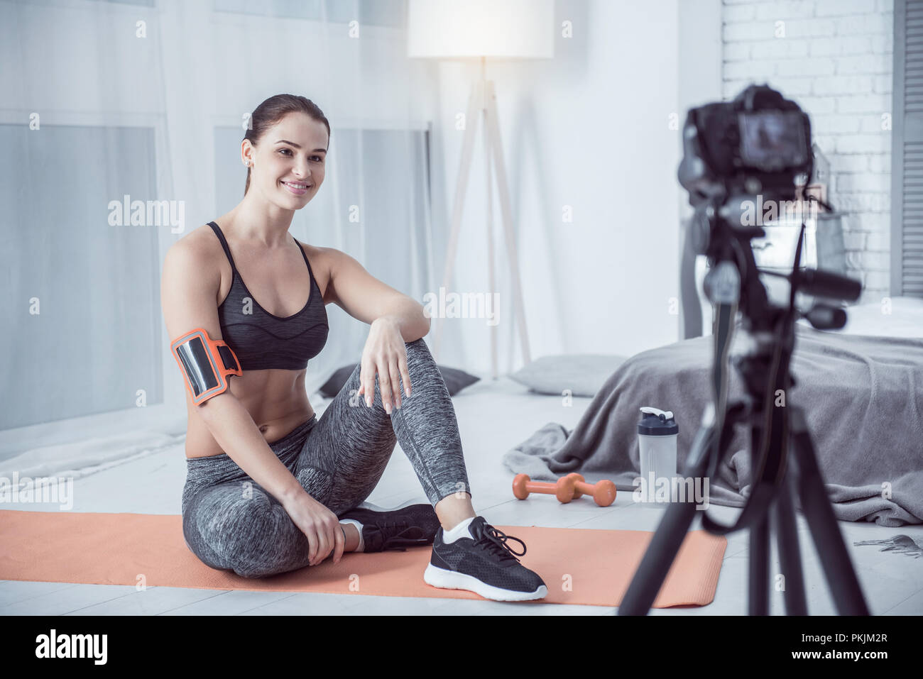 Delighted young woman sitting in front of the camera Stock Photo