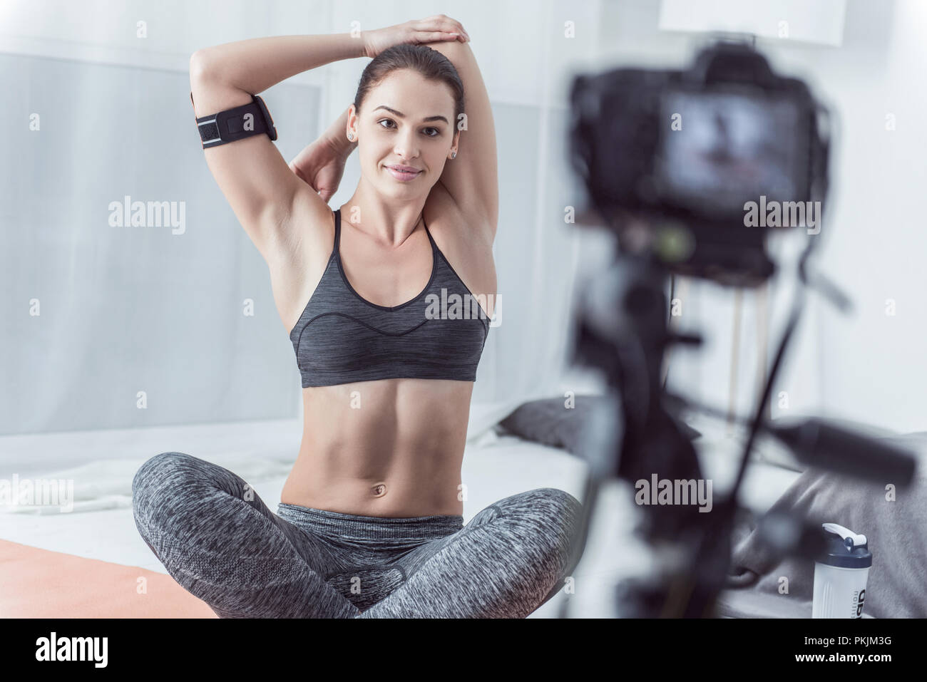 Positive delighted woman sitting on a yoga mat Stock Photo