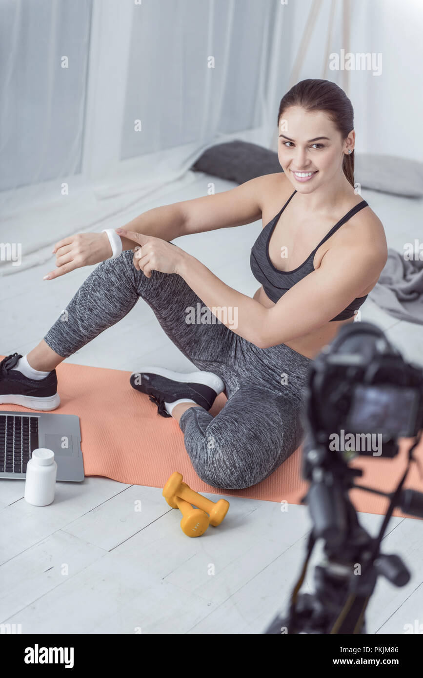 Joyful positive woman showing a fitness bracelet Stock Photo