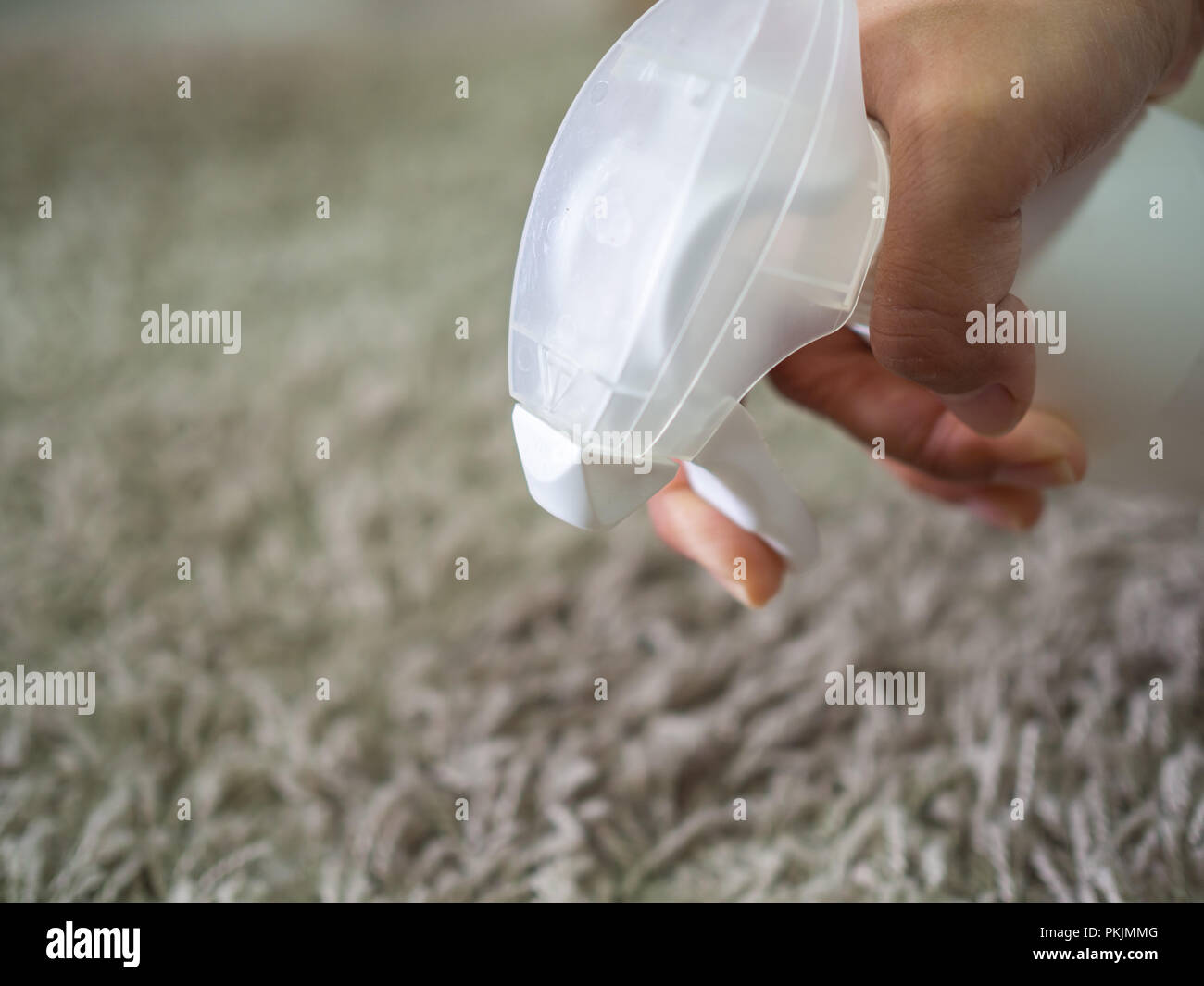 Closeup hand cleaning dirty carpet by detergent cleaning spray Stock