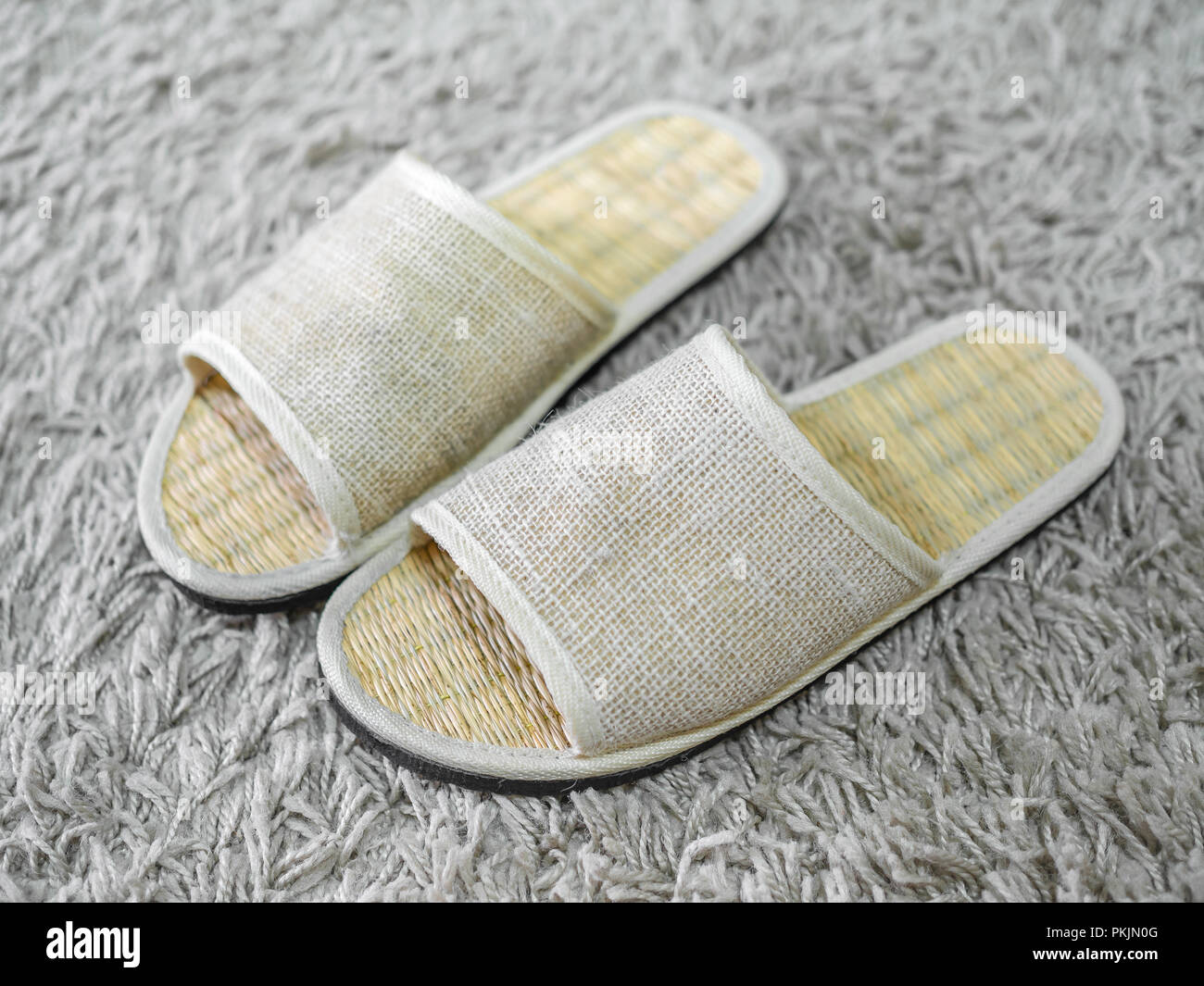 Weaving shoes on carpet. Weaving flip flops. Weaving sandal. Weaving slippers. Stock Photo