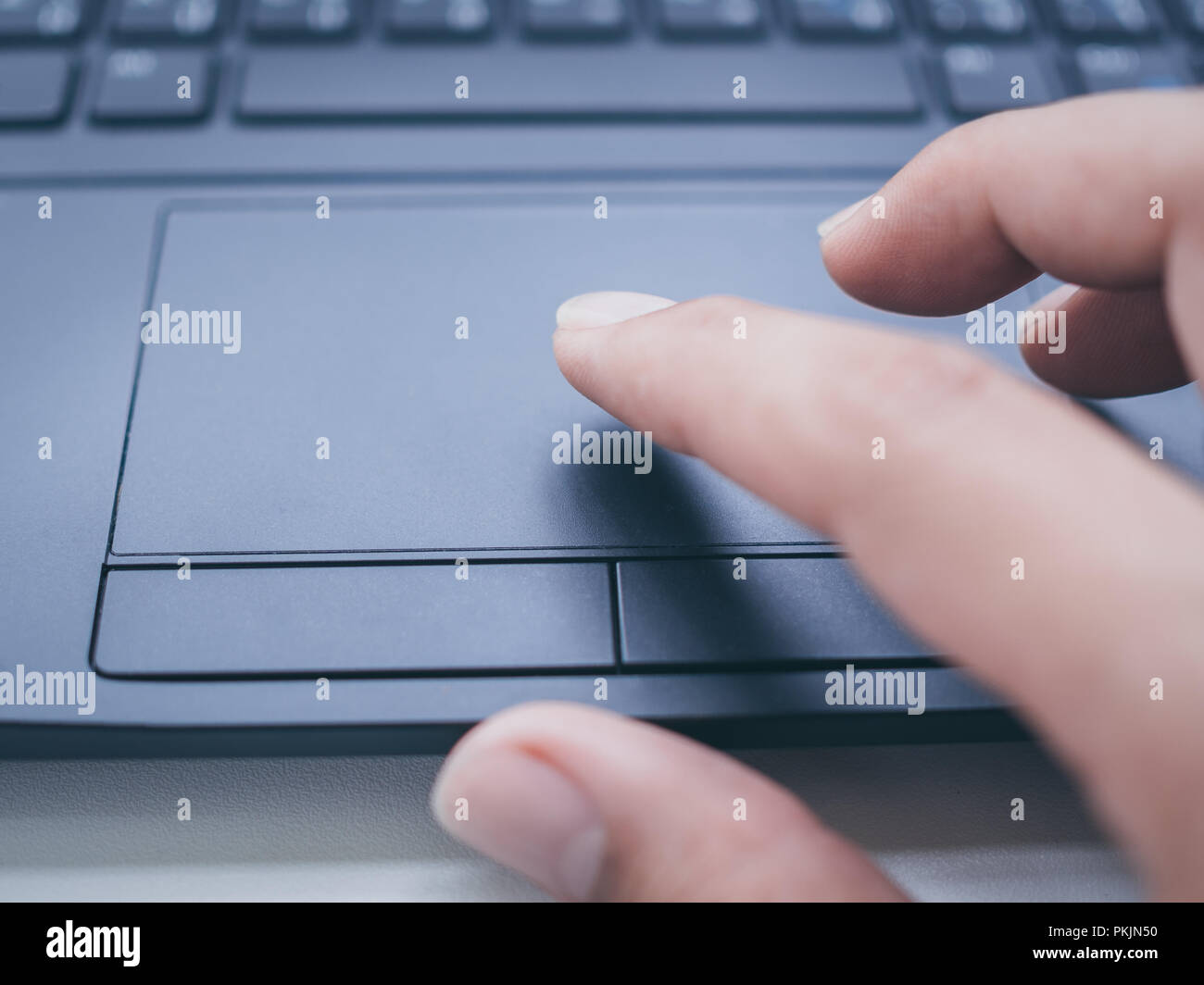 Closeup hands touching on touch pad on black laptop computer keyboard