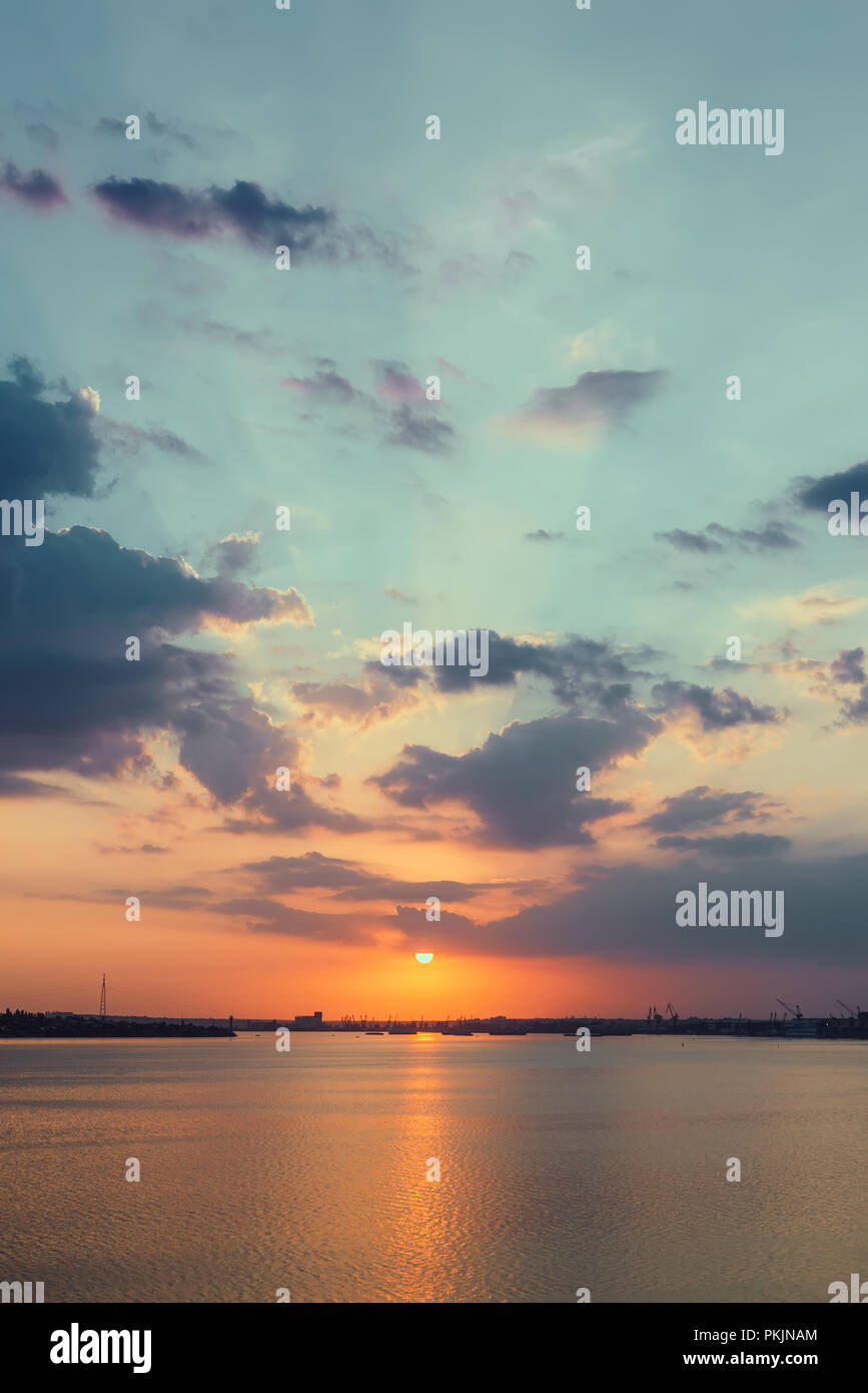 orange sunset in clouds over water Stock Photo - Alamy