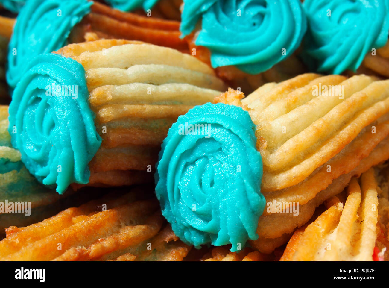 Spanish traditional frieddough pastry churros in in colored glaze