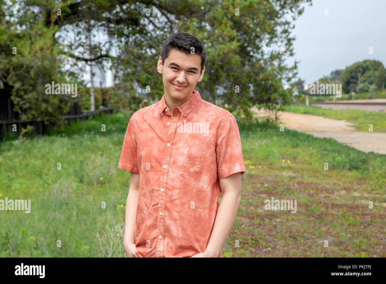 A 22 year old man standing outdoors with his hands in his pockets in Carlsbad, California Stock Photo